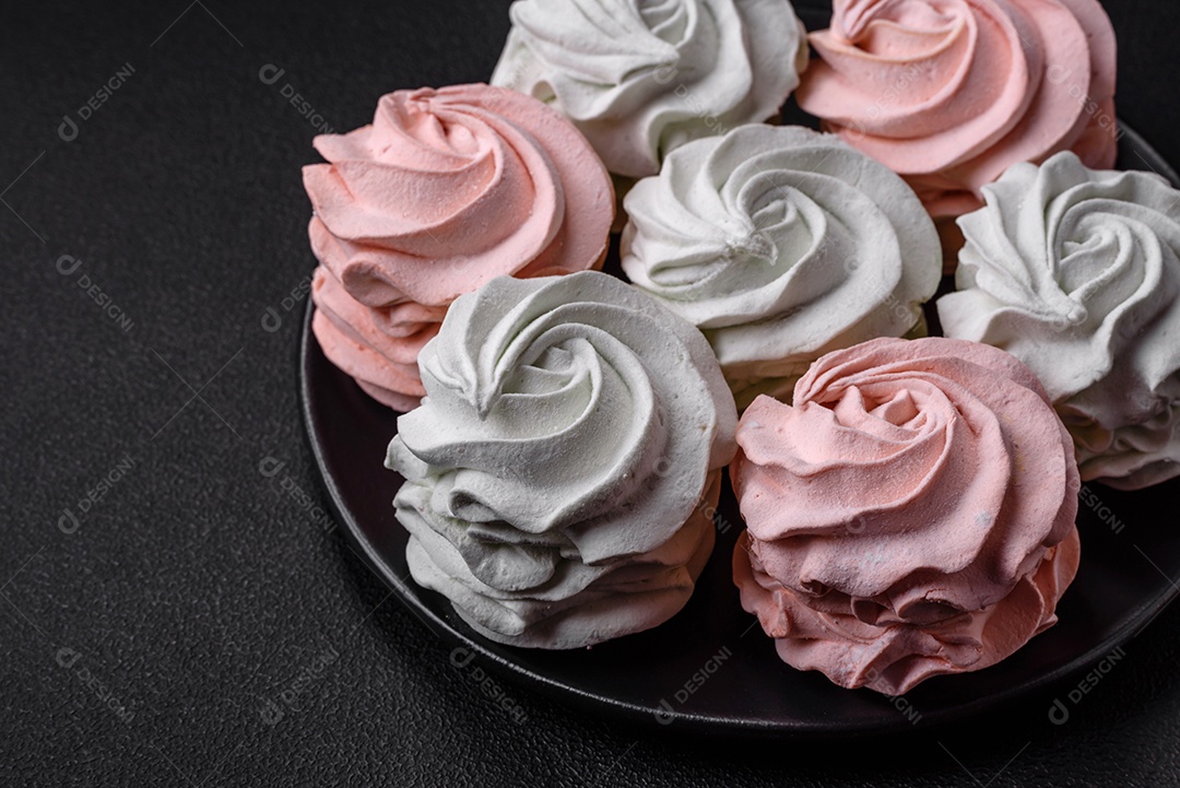 Delicioso marshmallow colorido doce em um fundo escuro de concreto. Doces saudáveis ​​para a mesa de jantar