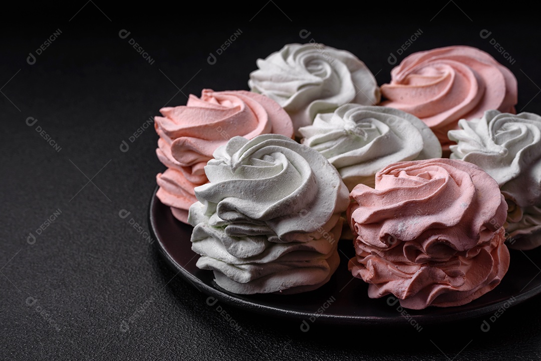 Delicioso marshmallow colorido doce em um fundo escuro de concreto. Doces saudáveis ​​para a mesa de jantar