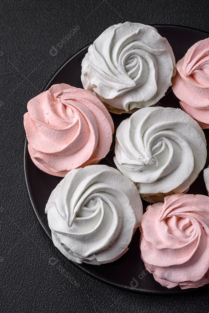 Delicioso marshmallow colorido doce em um fundo escuro de concreto. Doces saudáveis ​​para a mesa de jantar