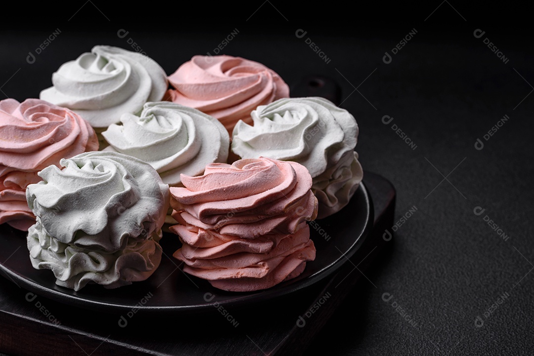 Delicioso marshmallow colorido doce em um fundo escuro de concreto. Doces saudáveis ​​para a mesa de jantar