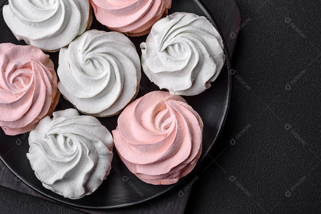 Delicioso marshmallow colorido doce em um fundo escuro de concreto. Doces saudáveis ​​para a mesa de jantar