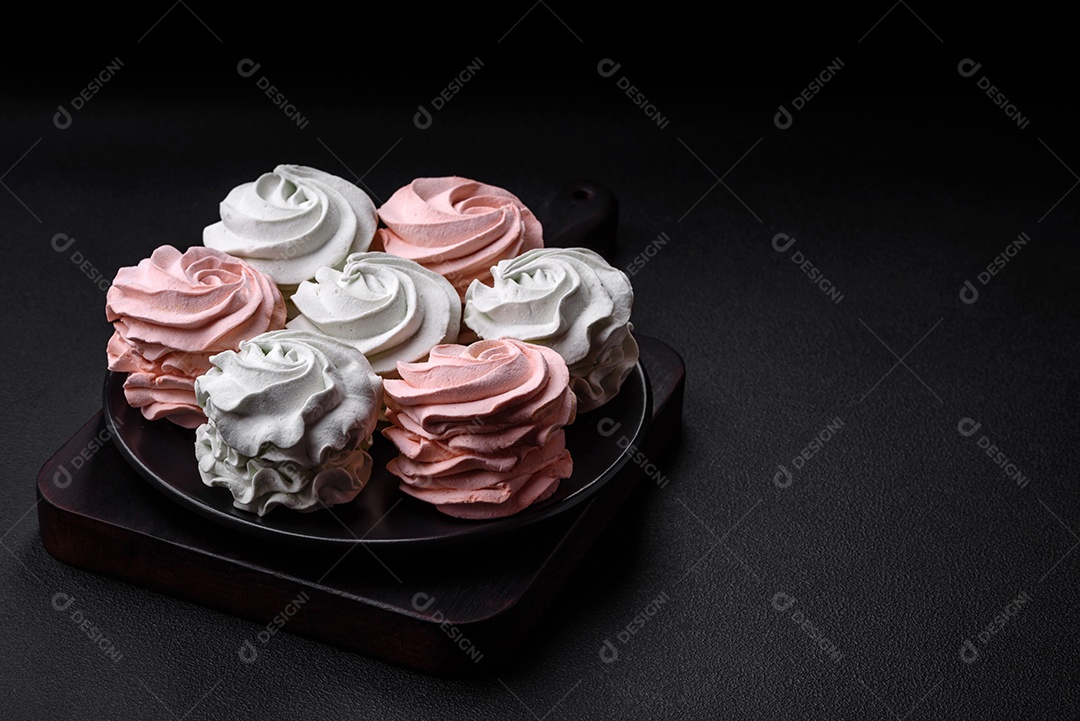Delicioso marshmallow colorido doce em um fundo escuro de concreto. Doces saudáveis ​​para a mesa de jantar