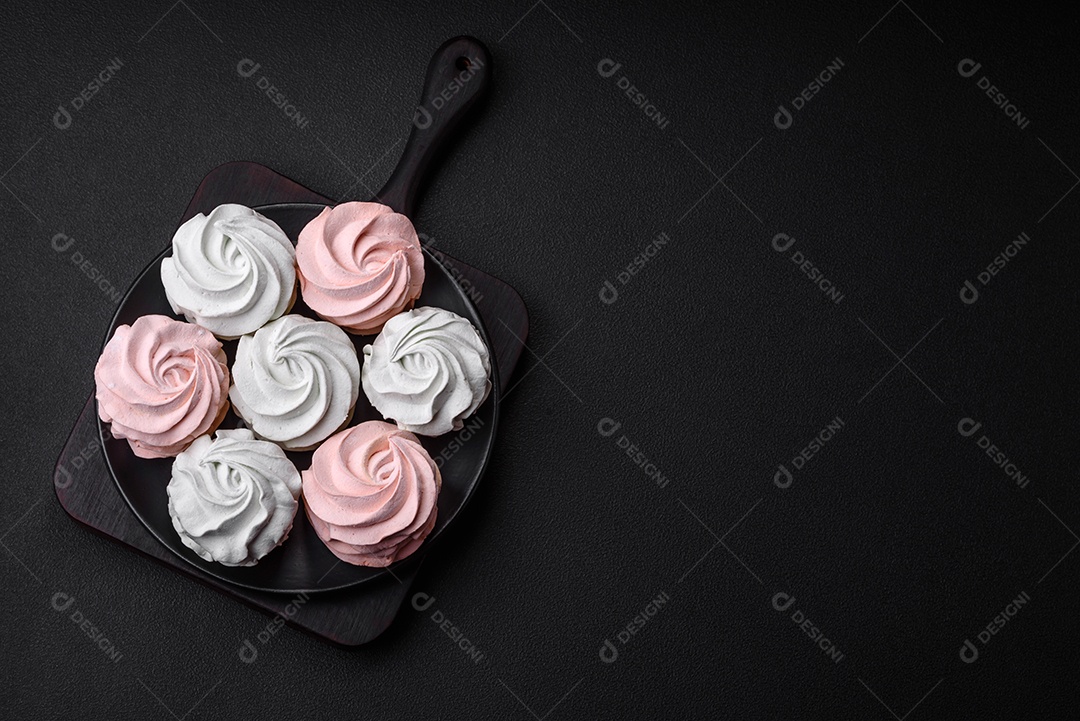 Delicioso marshmallow colorido doce em um fundo escuro de concreto. Doces saudáveis ​​para a mesa de jantar