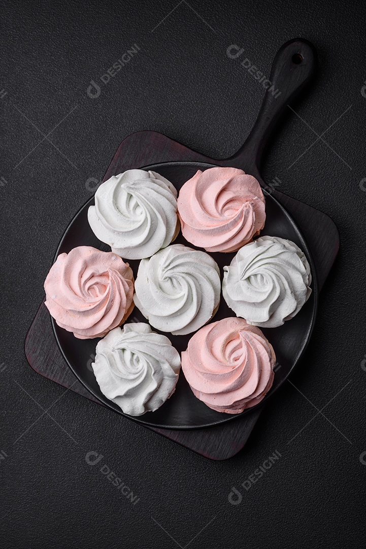 Delicioso marshmallow colorido doce em um fundo escuro de concreto. Doces saudáveis ​​para a mesa de jantar