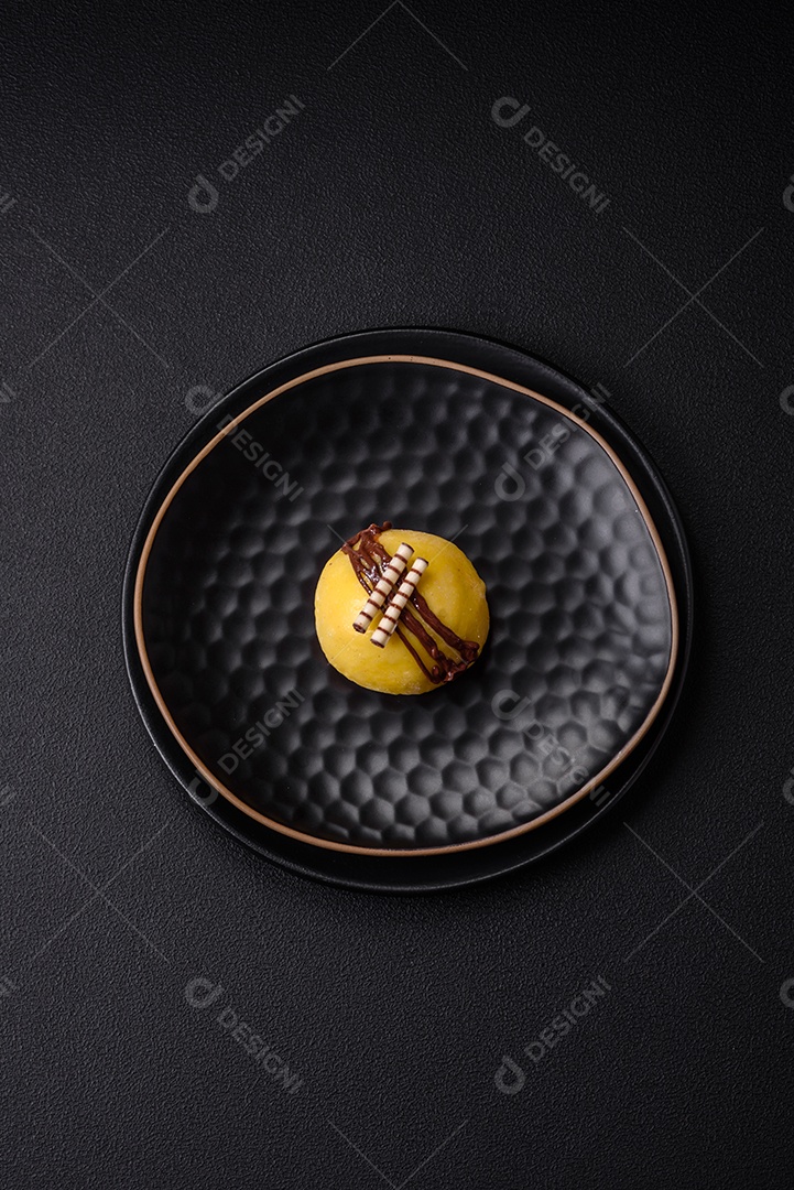 Deliciosas sobremesas mochi coloridas ou sorvete com massa de arroz e coberturas sobre um fundo escuro de concreto