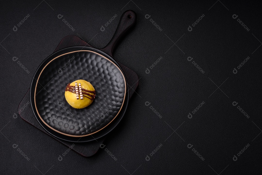 Deliciosas sobremesas mochi coloridas ou sorvete com massa de arroz e coberturas sobre um fundo escuro de concreto