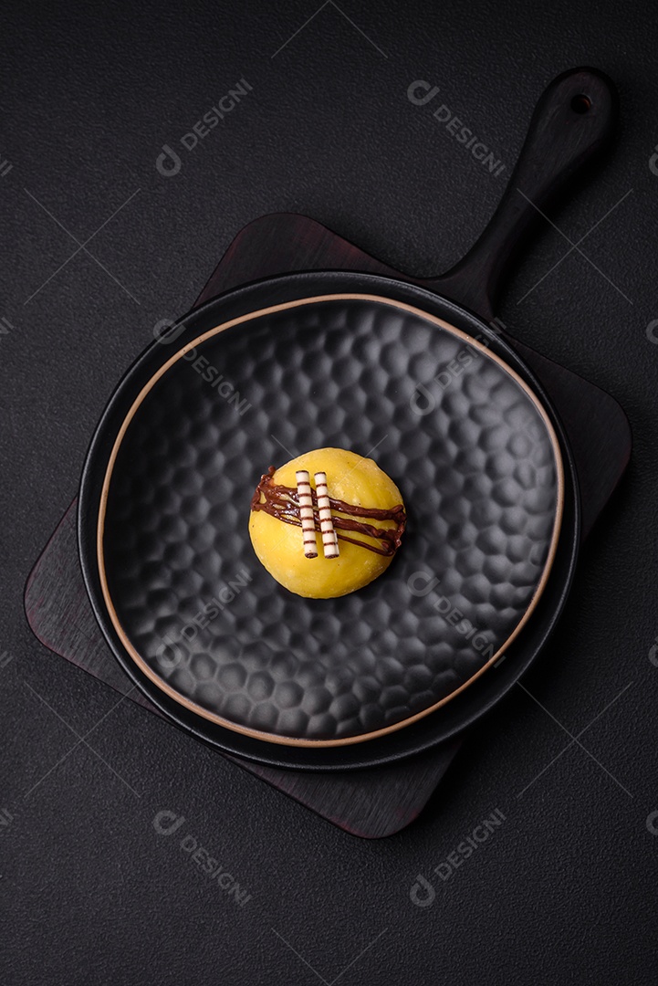 Deliciosas sobremesas mochi coloridas ou sorvete com massa de arroz e coberturas sobre um fundo escuro de concreto