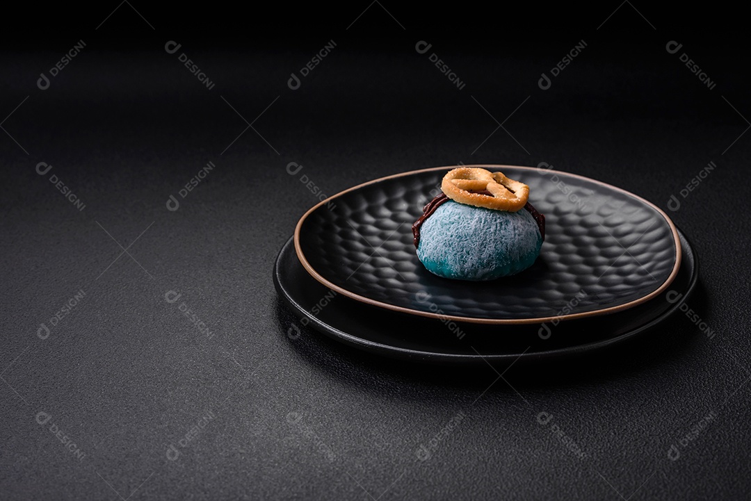 Deliciosas sobremesas mochi coloridas ou sorvete com massa de arroz e coberturas sobre um fundo escuro de concreto