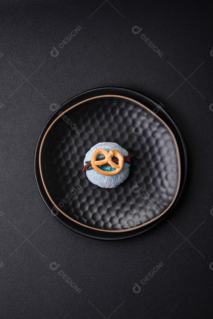 Deliciosas sobremesas mochi coloridas ou sorvete com massa de arroz e coberturas sobre um fundo escuro de concreto