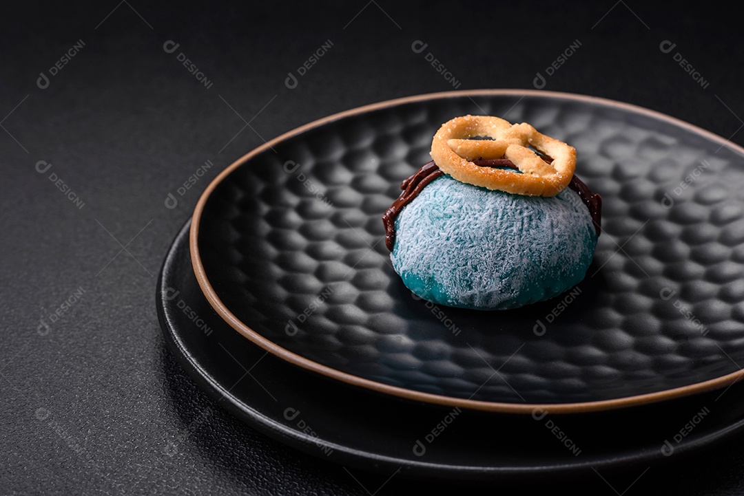 Deliciosas sobremesas mochi coloridas ou sorvete com massa de arroz e coberturas sobre um fundo escuro de concreto