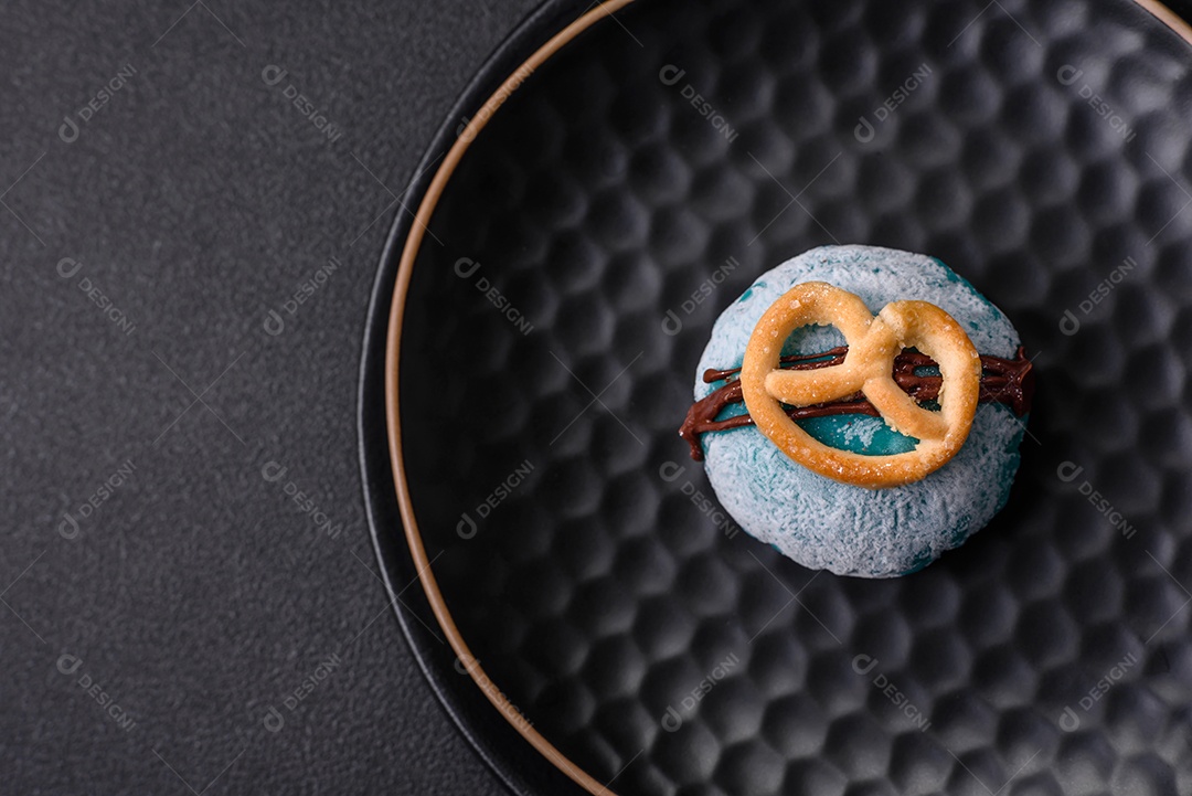 Deliciosas sobremesas mochi coloridas ou sorvete com massa de arroz e coberturas sobre um fundo escuro de concreto