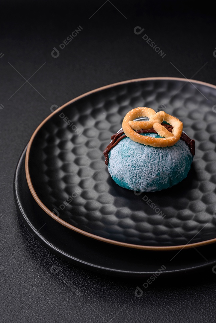 Deliciosas sobremesas mochi coloridas ou sorvete com massa de arroz e coberturas sobre um fundo escuro de concreto