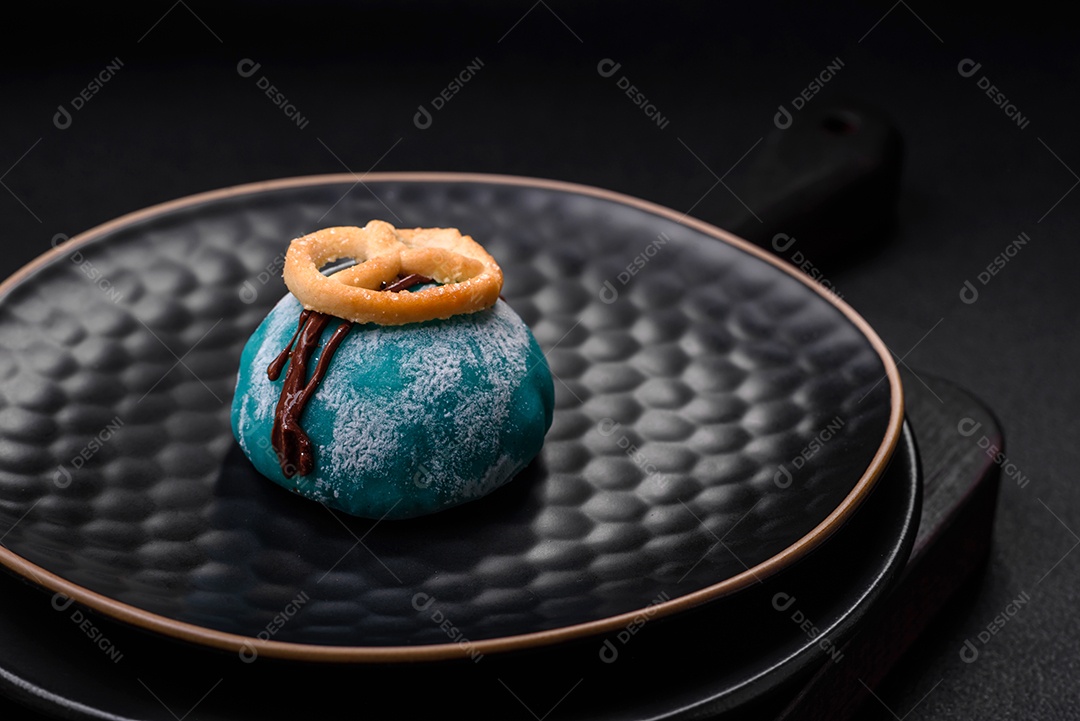 Deliciosas sobremesas mochi coloridas ou sorvete com massa de arroz e coberturas sobre um fundo escuro de concreto