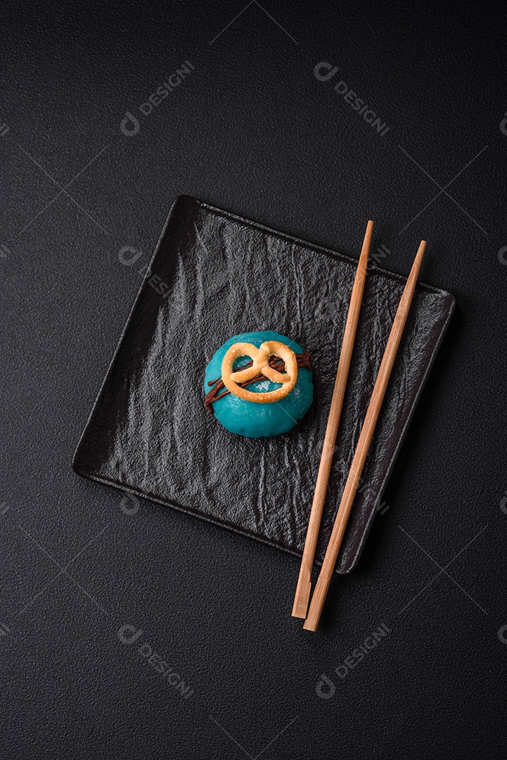 Deliciosas sobremesas mochi coloridas ou sorvete com massa de arroz e coberturas sobre um fundo escuro de concreto