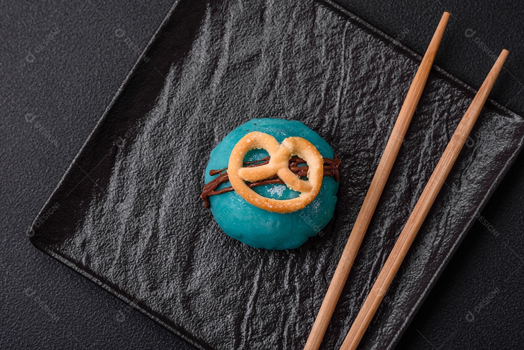 Deliciosas sobremesas mochi coloridas ou sorvete com massa de arroz e coberturas sobre um fundo escuro de concreto