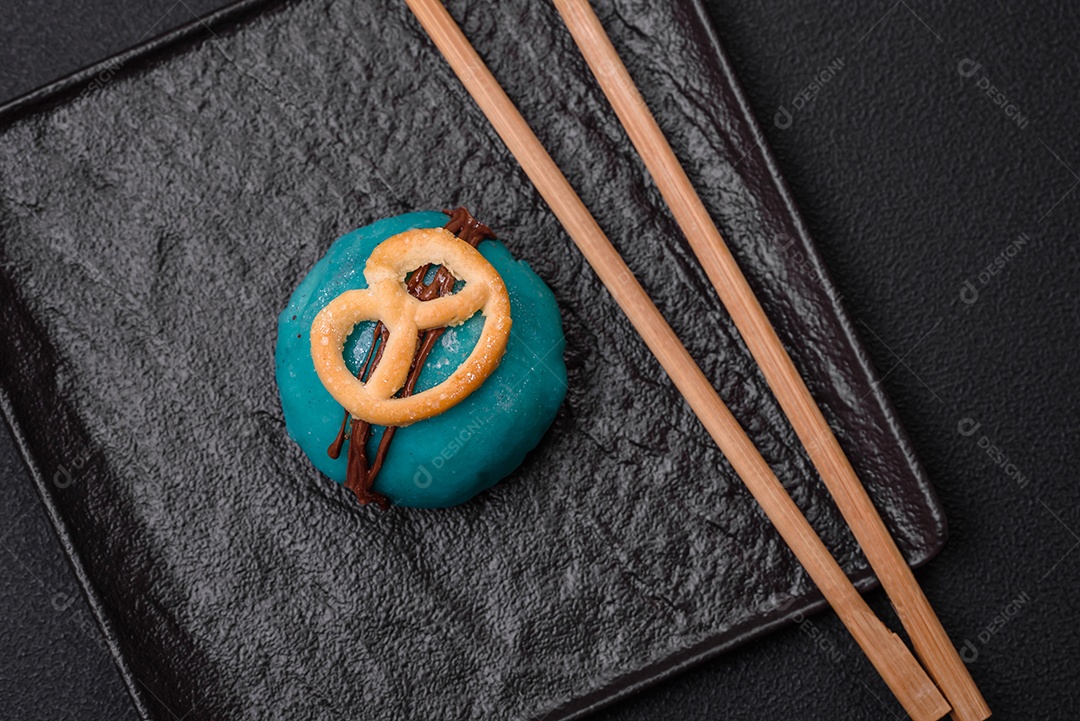 Deliciosas sobremesas mochi coloridas ou sorvete com massa de arroz e coberturas sobre um fundo escuro de concreto