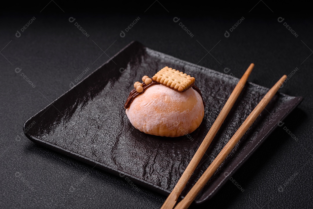 Deliciosas sobremesas mochi coloridas ou sorvete com massa de arroz e coberturas sobre um fundo escuro de concreto