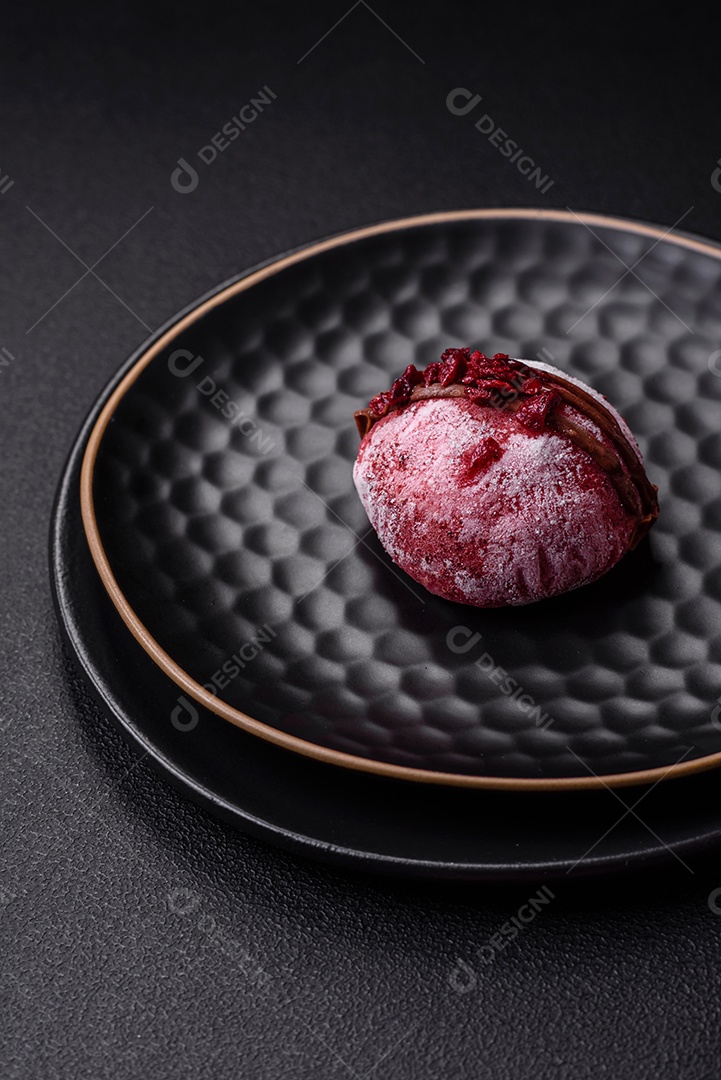 Deliciosas sobremesas mochi coloridas ou sorvete com massa de arroz e coberturas sobre um fundo escuro de concreto