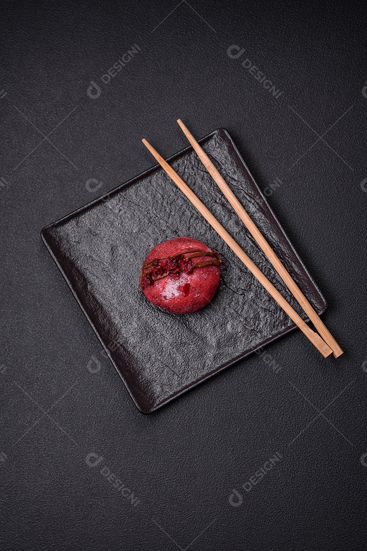 Deliciosas sobremesas mochi coloridas ou sorvete com massa de arroz e coberturas sobre um fundo escuro de concreto