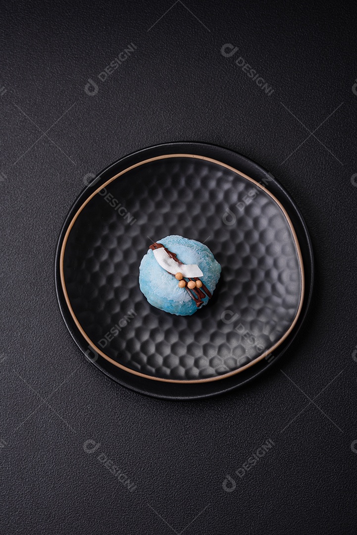 Deliciosas sobremesas mochi coloridas ou sorvete com massa de arroz e coberturas sobre um fundo escuro de concreto