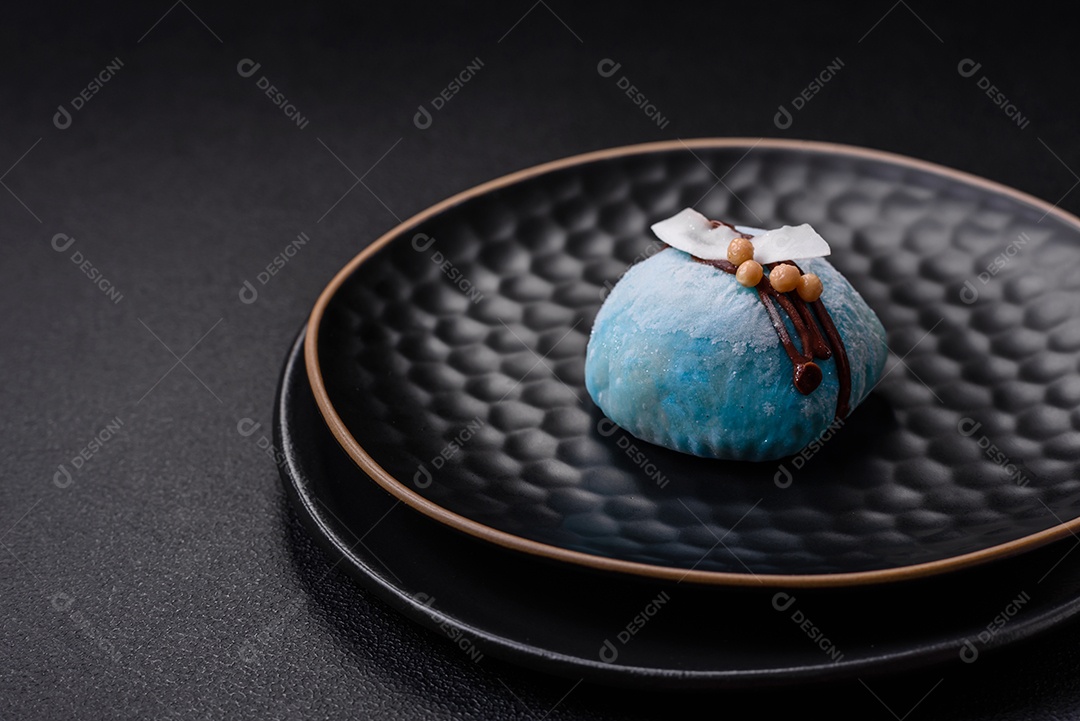 Deliciosas sobremesas mochi coloridas ou sorvete com massa de arroz e coberturas sobre um fundo escuro de concreto