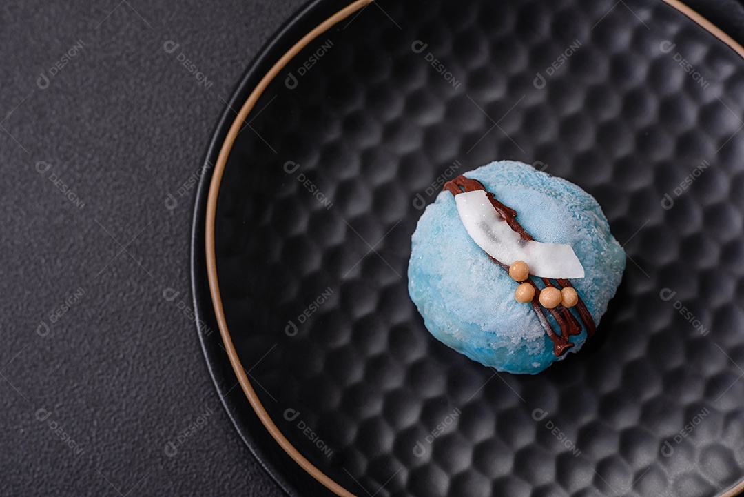 Deliciosas sobremesas mochi coloridas ou sorvete com massa de arroz e coberturas sobre um fundo escuro de concreto