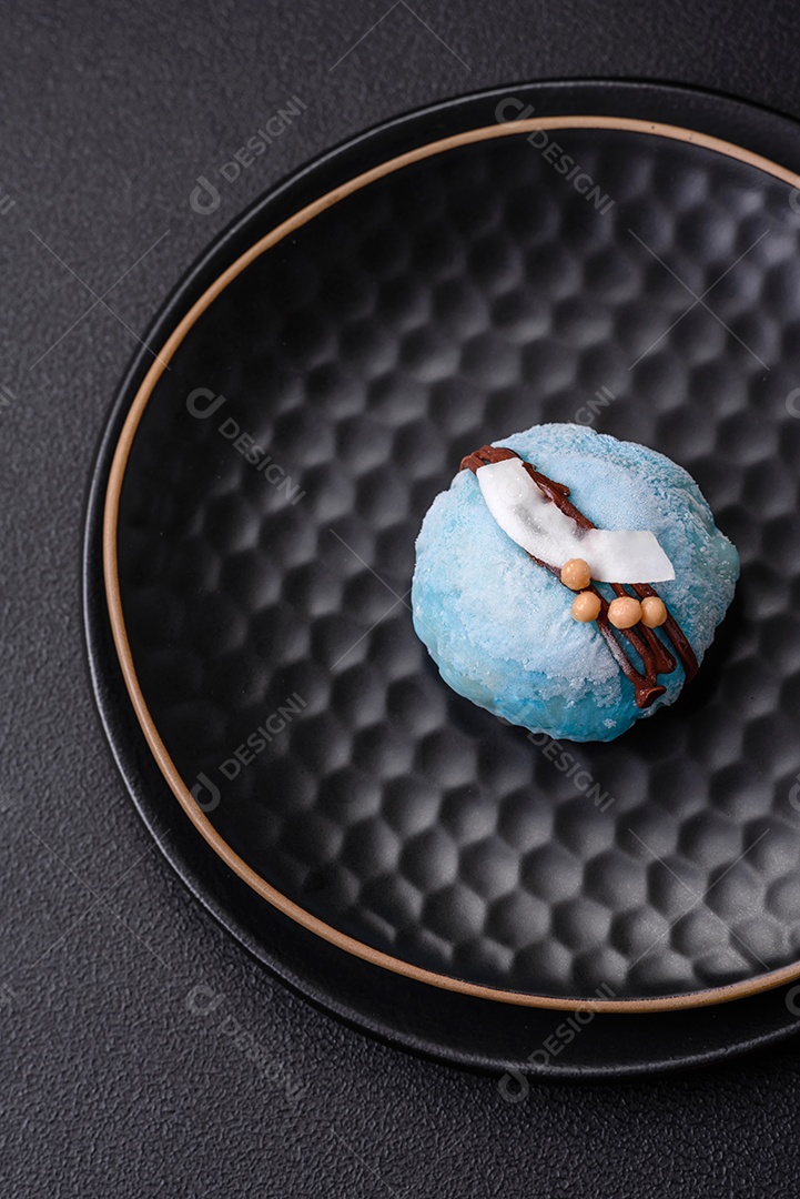 Deliciosas sobremesas mochi coloridas ou sorvete com massa de arroz e coberturas sobre um fundo escuro de concreto