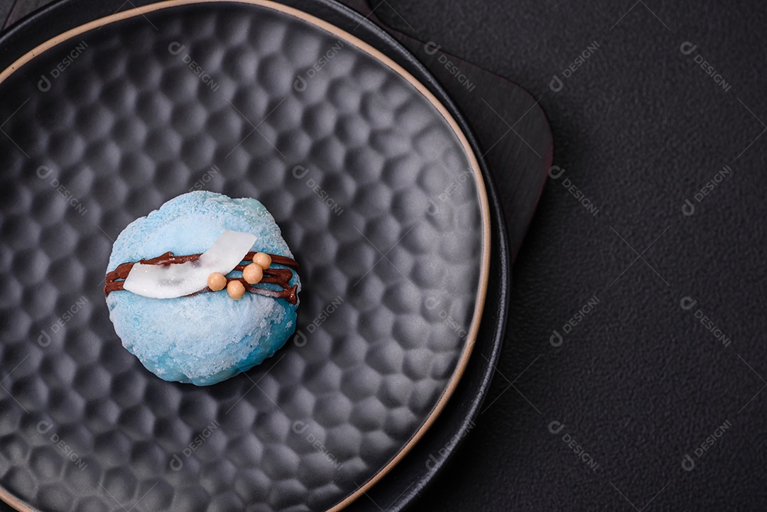 Deliciosas sobremesas mochi coloridas ou sorvete com massa de arroz e coberturas sobre um fundo escuro de concreto