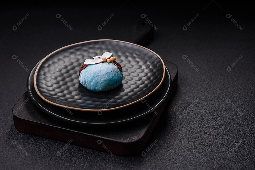 Deliciosas sobremesas mochi coloridas ou sorvete com massa de arroz e coberturas sobre um fundo escuro de concreto