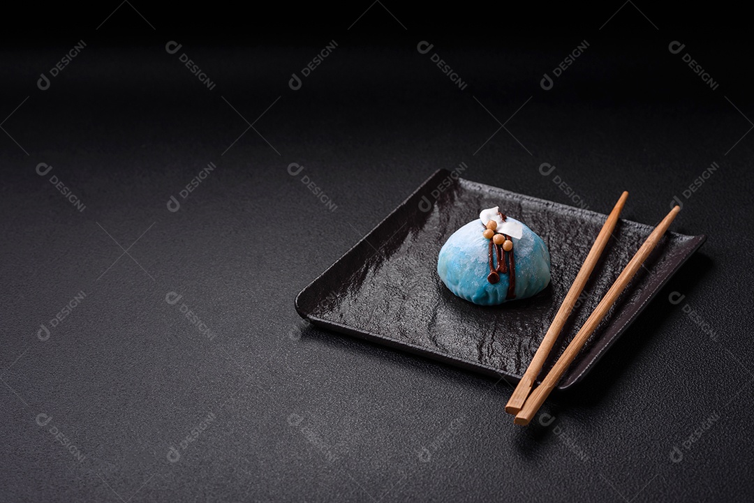 Deliciosas sobremesas mochi coloridas ou sorvete com massa de arroz e coberturas sobre um fundo escuro de concreto