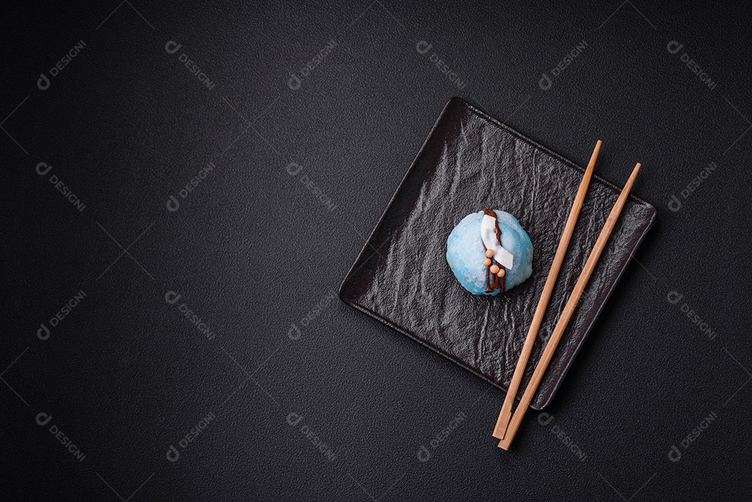 Deliciosas sobremesas mochi coloridas ou sorvete com massa de arroz e coberturas sobre um fundo escuro de concreto