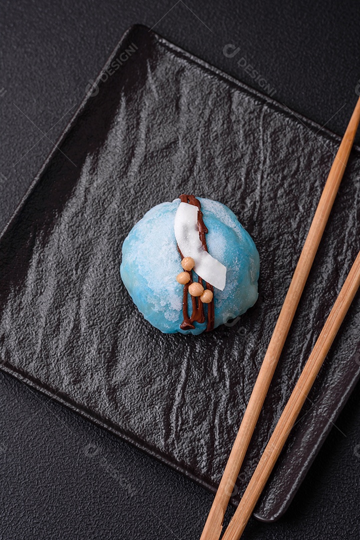 Deliciosas sobremesas mochi coloridas ou sorvete com massa de arroz e coberturas sobre um fundo escuro de concreto