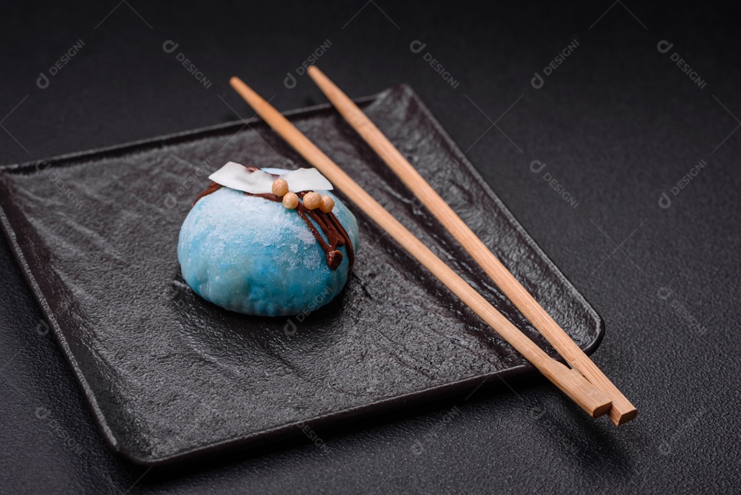 Deliciosas sobremesas mochi coloridas ou sorvete com massa de arroz e coberturas sobre um fundo escuro de concreto