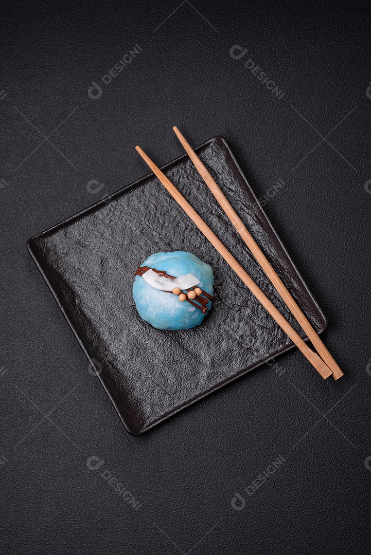 Deliciosas sobremesas mochi coloridas ou sorvete com massa de arroz e coberturas sobre um fundo escuro de concreto