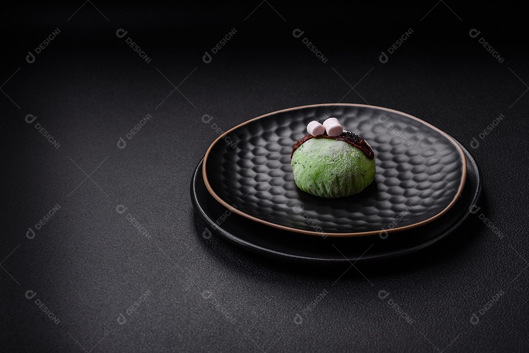 Deliciosas sobremesas mochi coloridas ou sorvete com massa de arroz e coberturas sobre um fundo escuro de concreto