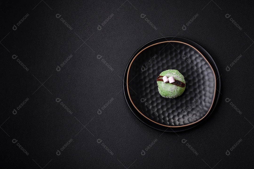 Deliciosas sobremesas mochi coloridas ou sorvete com massa de arroz e coberturas sobre um fundo escuro de concreto