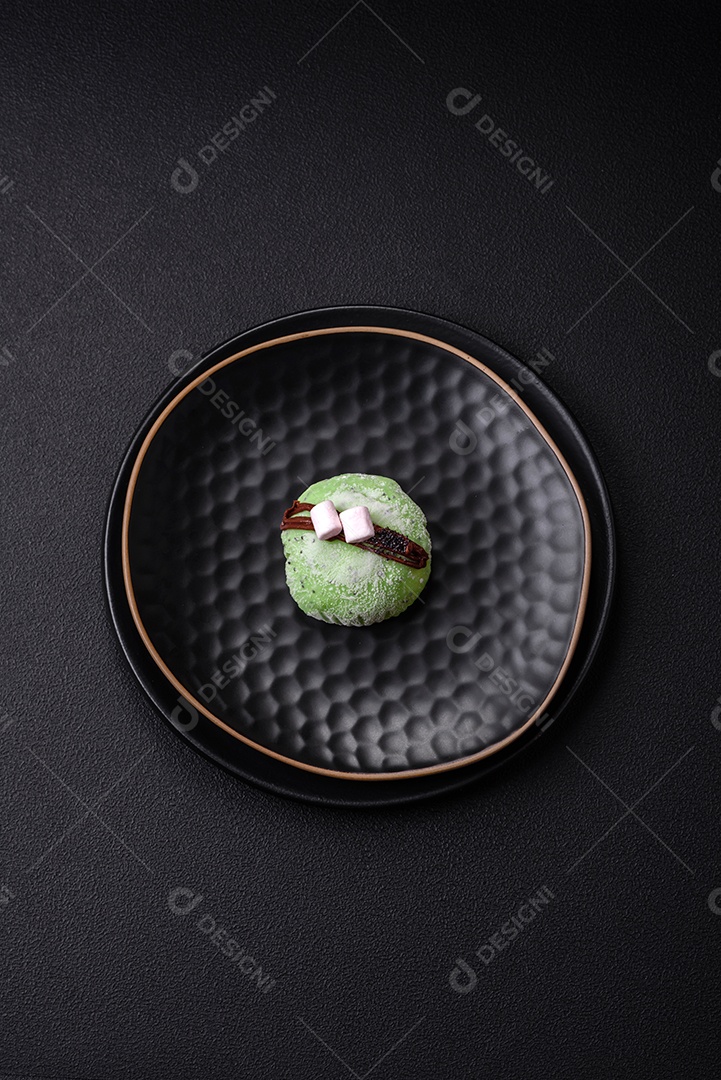 Deliciosas sobremesas mochi coloridas ou sorvete com massa de arroz e coberturas sobre um fundo escuro de concreto