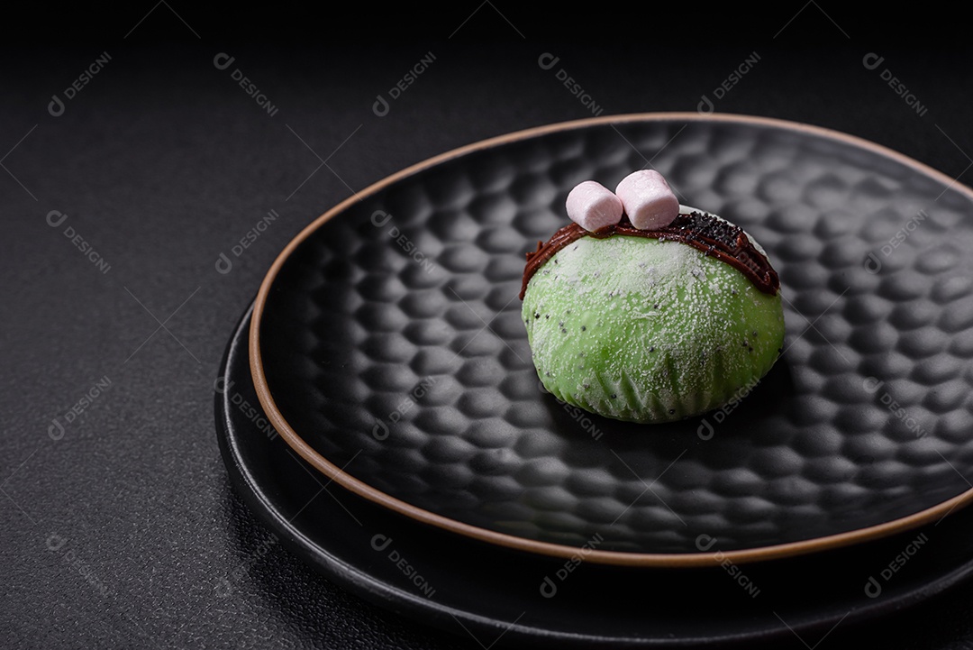 Deliciosas sobremesas mochi coloridas ou sorvete com massa de arroz e coberturas sobre um fundo escuro de concreto