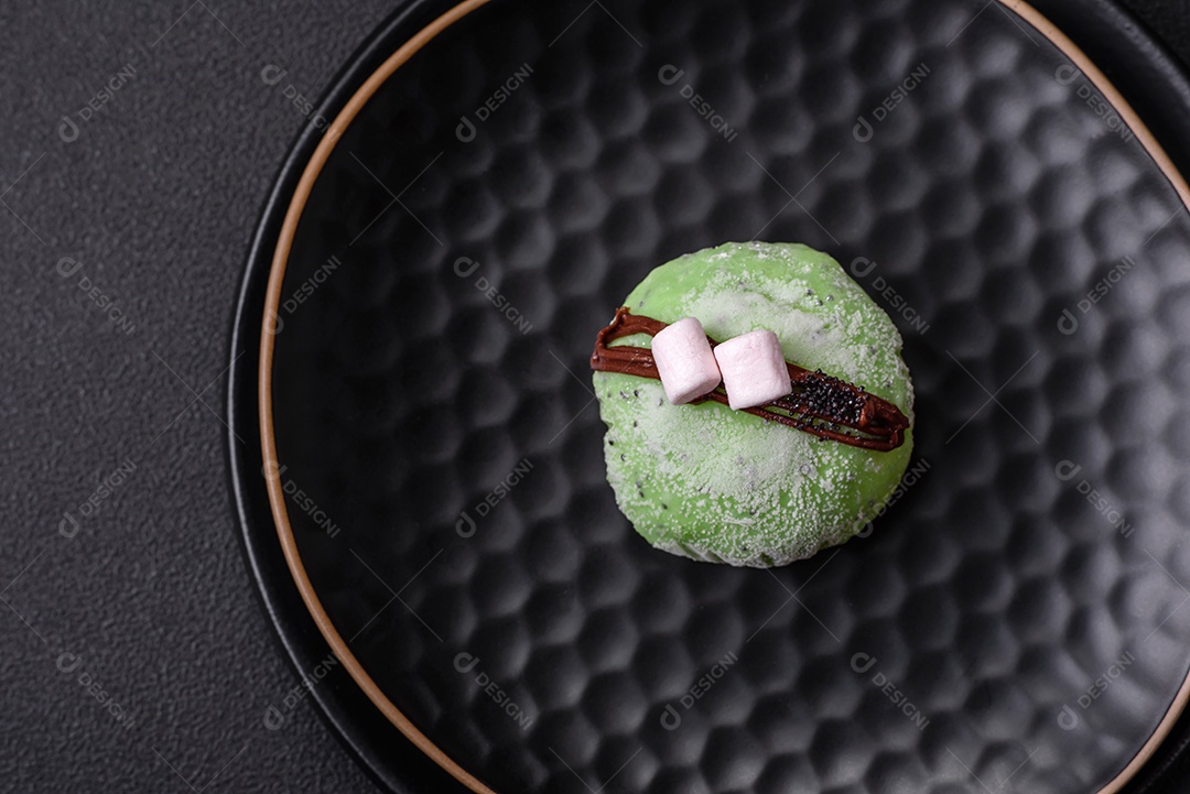 Deliciosas sobremesas mochi coloridas ou sorvete com massa de arroz e coberturas sobre um fundo escuro de concreto