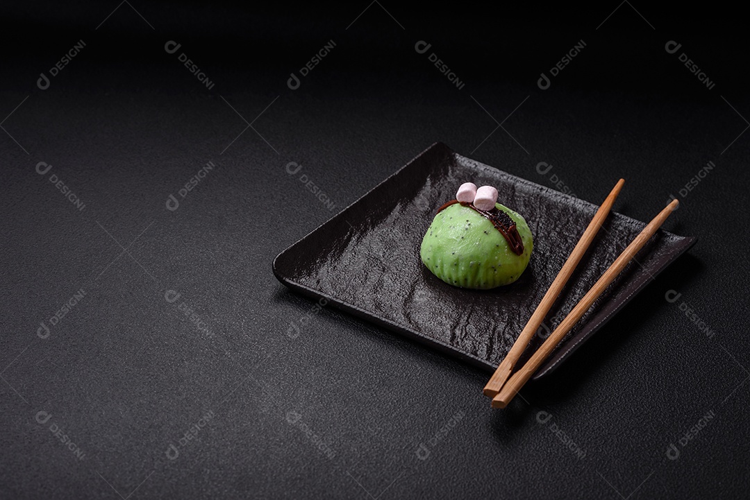 Deliciosas sobremesas mochi coloridas ou sorvete com massa de arroz e coberturas sobre um fundo escuro de concreto