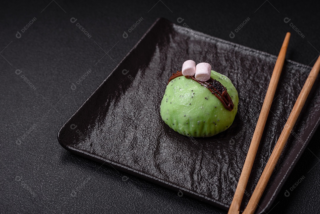 Deliciosas sobremesas mochi coloridas ou sorvete com massa de arroz e coberturas sobre um fundo escuro de concreto