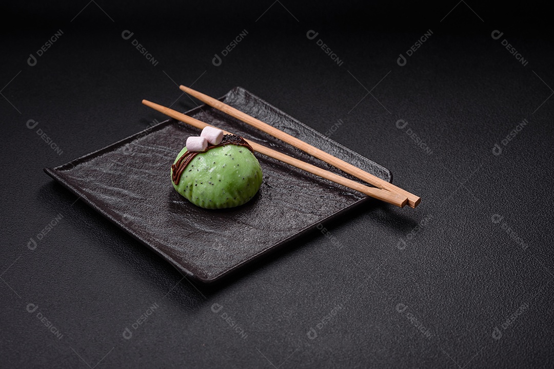 Deliciosas sobremesas mochi coloridas ou sorvete com massa de arroz e coberturas sobre um fundo escuro de concreto