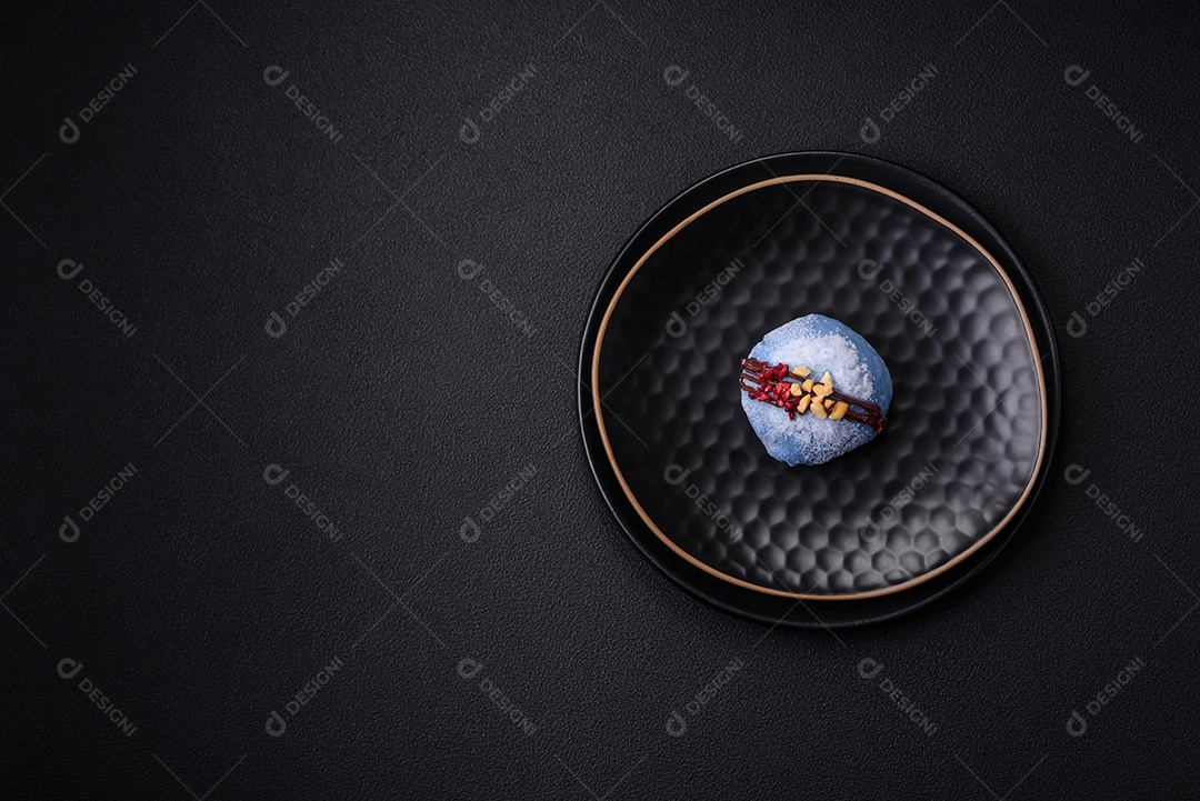 Deliciosas sobremesas mochi coloridas ou sorvete com massa de arroz e coberturas sobre um fundo escuro de concreto