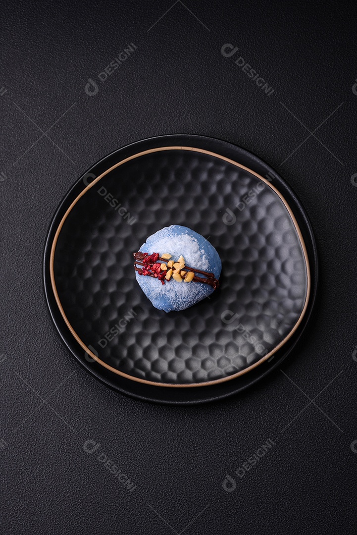 Deliciosas sobremesas mochi coloridas ou sorvete com massa de arroz e coberturas sobre um fundo escuro de concreto