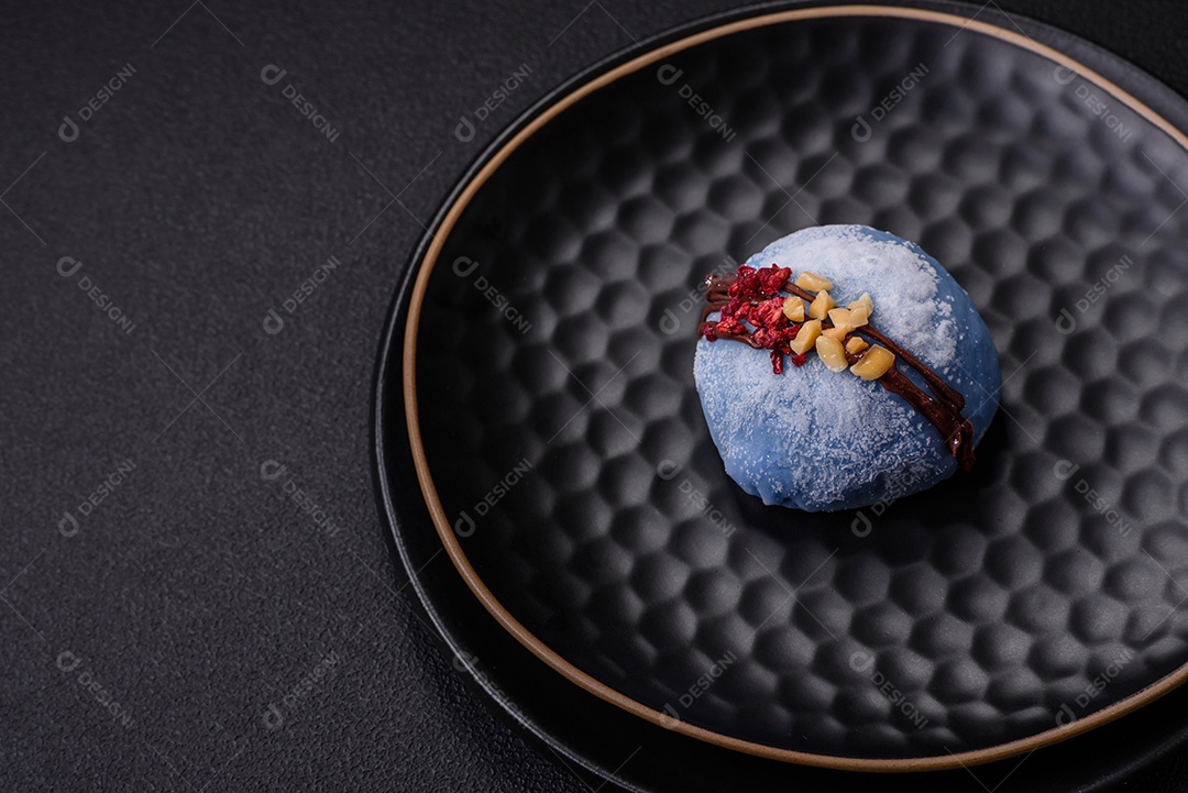 Deliciosas sobremesas mochi coloridas ou sorvete com massa de arroz e coberturas sobre um fundo escuro de concreto