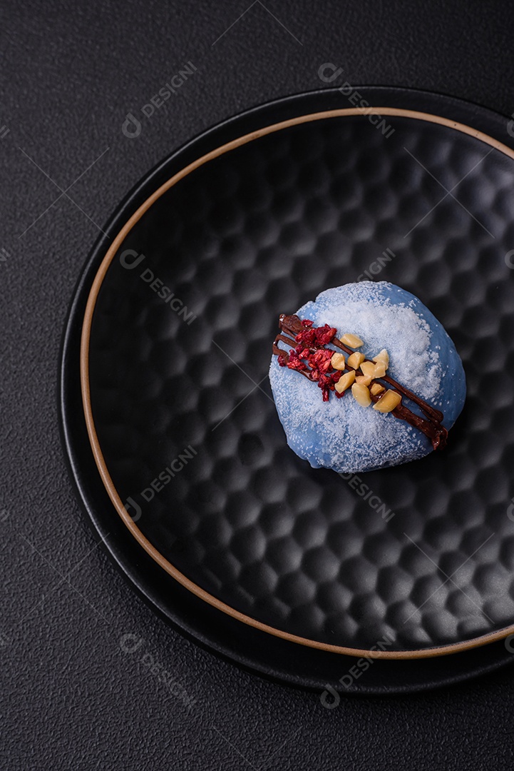 Deliciosas sobremesas mochi coloridas ou sorvete com massa de arroz e coberturas sobre um fundo escuro de concreto