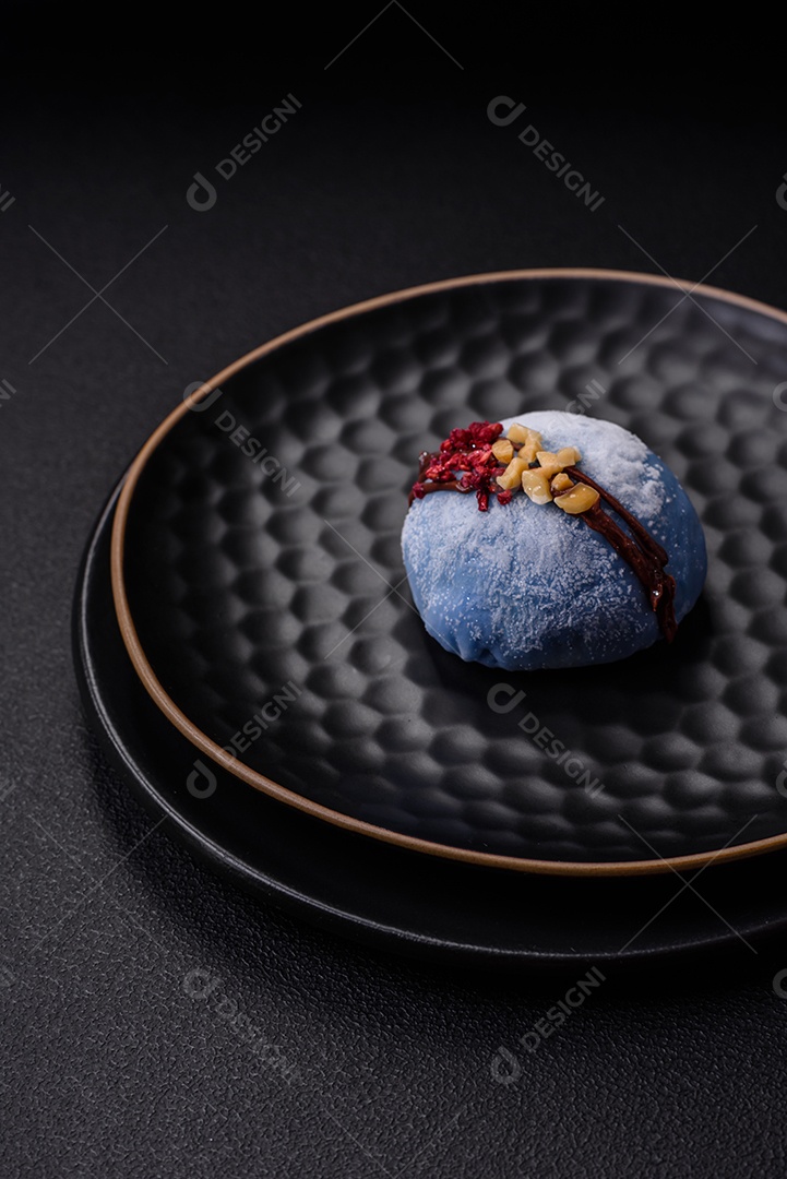 Deliciosas sobremesas mochi coloridas ou sorvete com massa de arroz e coberturas sobre um fundo escuro de concreto