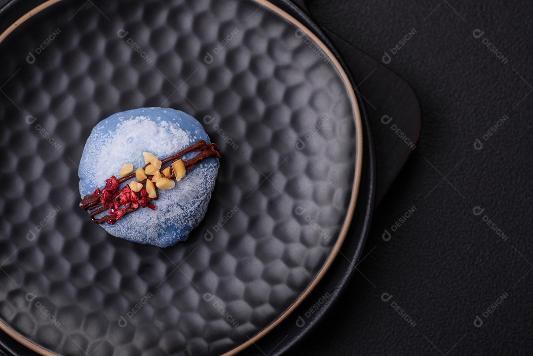 Deliciosas sobremesas mochi coloridas ou sorvete com massa de arroz e coberturas sobre um fundo escuro de concreto