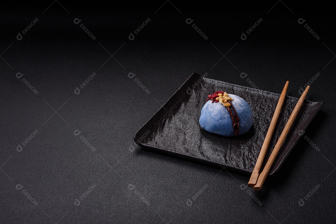 Deliciosas sobremesas mochi coloridas ou sorvete com massa de arroz e coberturas sobre um fundo escuro de concreto