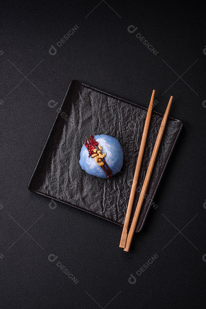 Deliciosas sobremesas mochi coloridas ou sorvete com massa de arroz e coberturas sobre um fundo escuro de concreto